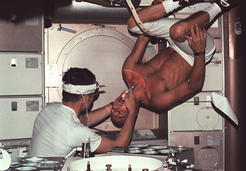 Skylab 1 commander Pete Conrad undergoes a dental examination by medical officer Joseph Kerwin. &ndash; Credits: NASA.